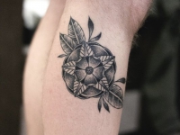 Татуировка абстрактного цветка с листиками на руке