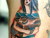 Татуировка девушки обнимающей голову коровы на руке