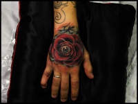 Татуировка роза с глазом на кисти руки