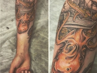 Татуировка осьминога опутываещего щупальцами корабль на руке