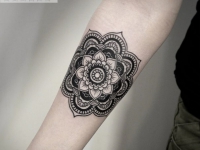 Татуировка цветок из узоров на предплечье