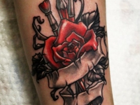 Татуировка на руке красная роза и кисти художника связанные лентой