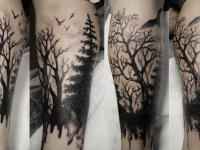 Татуировка темный лес и кружащиеся над ним вороны на руке