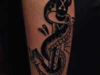 Татуировка змеи опутывающей кинжал на руке