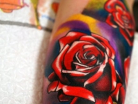 Татуировка в виде ярких разноцветных роз на внутренней части предплечья