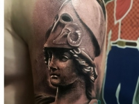 Татуировка голова в шлеме на плече