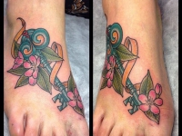 Татуировка ключ в цветах на ступне