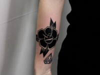 Татуировка черного цветка и кристала на руке
