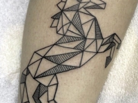 Татуировка единорога из треугольников на ноге