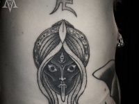 Татуировка голова восточной женщины с символикой на боку