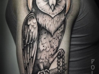 Татуировка совы с четками на плече