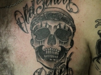 Татуировка череп с надписью на груди