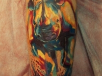 Татуировка цветного носорога на колене