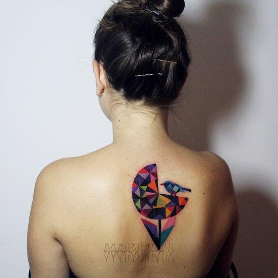Художественная татуировка «Птичка на цветке» от Саши Унисекс. Татуировка сделана на спине девушки по индивидуальному эскизу мастера. Время работы — около трёх часов.